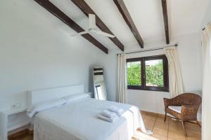 a white bedroom with a bed and a window at Villa Bini Andu in Binibeca +25 photos