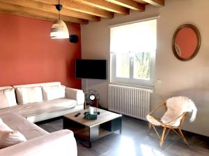 a living room with a couch and a table at Gite Fleur De Miel in Saffloz