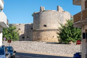 a castle with a stone wall next to a street at Micenei Homes in Otranto