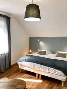 a bedroom with a large bed and a large window at Gite Fleur De Miel in Saffloz