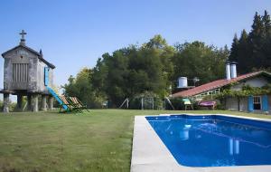 a swimming pool in a yard next to a house at Casa Con Encanto in Bueu