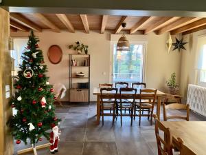 a christmas tree in a room with a table and chairs at Gite Fleur De Miel in Saffloz