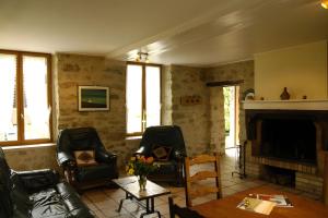 a living room with two chairs and a fireplace at Haras de la fontaine Diva in Poligny