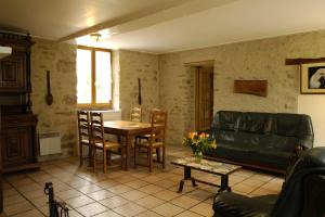 a living room with a couch and a table at Haras de la fontaine Diva in Poligny +4 photos