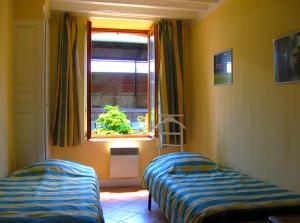 a bedroom with two beds and a window at Haras de la fontaine Diva in Poligny