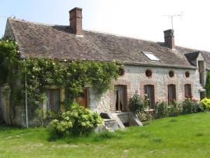 an old stone house with ivy on it at Haras de la fontaine Diva in Poligny