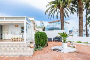 a house with a patio and palm trees at Casa Vesalia in Vinarós