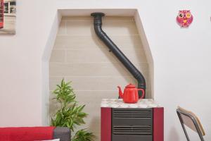 a red kettle on a table in a room at La Nicchia in Tirli
