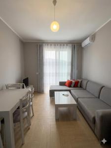 a living room with a couch and a table at Radhima Beach Apartments in Vlorë