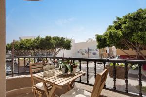 a balcony with a wooden table and chairs on a city street at Apartamento Puerto Playa in Puerto del Rosario