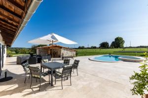 a patio with a table and chairs and a pool at Le Basque - Bazas in Bazas