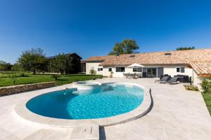a swimming pool with a patio and a house at Le Basque - Bazas in Bazas