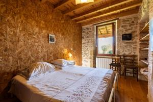 a bedroom with a bed in a stone wall at Le Basque - Bazas in Bazas +23 photos