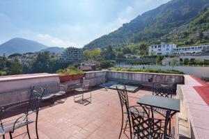 a patio with chairs and tables on a roof at Le Suite del Castello in Castellammare di Stabia