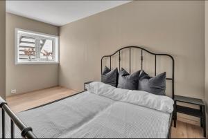 a bedroom with a bed with pillows and a window at Sunny Central in Kristiansand