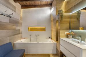 a bathroom with a tub and a sink at Casa Miranda 2 in Araya +16 photos