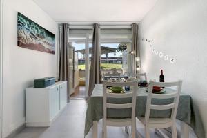 a dining room with a table and chairs and a window at Tróia Beach House in Carvalhal