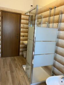a bathroom with a glass shower and a toilet at Sole Apartment in Rimini