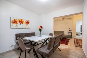 a dining room with a white table and chairs at Aldars Urban Loft Suite No.8 in Munich