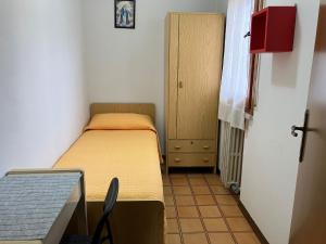 a small room with a bed and a small cabinet at Sole Apartment in Rimini
