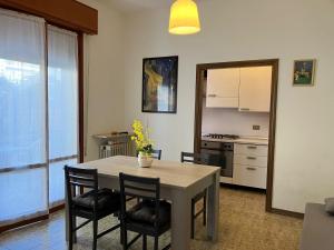 a kitchen and dining room with a table and chairs at Sole Apartment in Rimini +13 photos