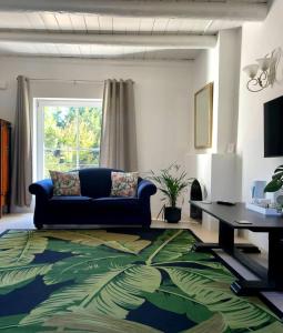 a living room with a blue couch and a table at La Jolie Dauphine Guest House in Franschhoek