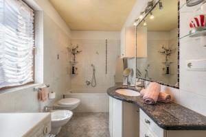 a bathroom with a sink and a toilet and a tub at Apartment Schlernblick in Umes
