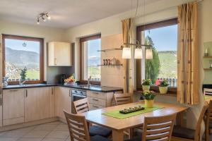 a kitchen and dining room with a table and chairs at Apartment Schlernblick in Umes