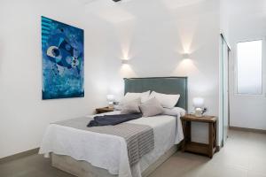 a bedroom with a bed with a blue painting on the wall at Casa Mara 1 in Playa Quemada