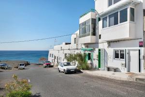 a white building on a street next to the ocean at Casa Mara 1 in Playa Quemada