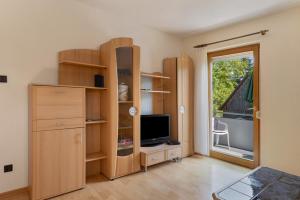 a room with wooden shelves and a tv and a window at Wein- Und Obstbau Rupp in Obersulm