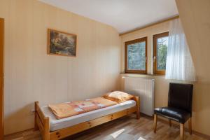a small bedroom with a bed and a chair at Wein- Und Obstbau Rupp in Obersulm