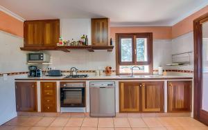 a kitchen with wooden cabinets and stainless steel appliances at Son Grau in Alaró