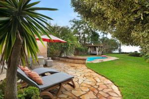 a backyard with a pool and a chair and a palm tree at Casa Anakena in Guía de Isora