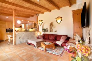 a living room with a red couch and a kitchen at Casa Anakena in Guía de Isora