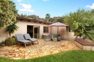 a patio with two chairs and an umbrella at Casa Anakena in Guía de Isora