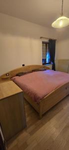 a bedroom with a wooden bed in a room at La Locanda dei Nonni in Pozza di Fassa