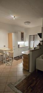 a kitchen with a counter and a table in it at La Locanda dei Nonni in Pozza di Fassa