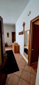 a room with a door and a mirror and a bathroom at La Locanda dei Nonni in Pozza di Fassa