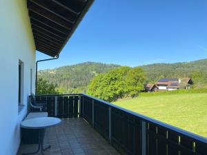 a balcony with a table and a view of a field at Fe-Wo Berg und See in Hauzenberg