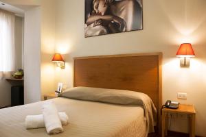 una camera con un letto, due lampade e un orologio di Hotel Terminal a Roma