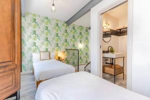 two beds in a room with a wall mural at Camarón Suite in Granada