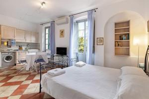 a bedroom with a large bed and a kitchen at Monolocale Isotta in Finale Ligure