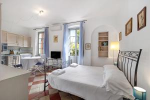 a bedroom with a large bed and a kitchen at Monolocale Isotta in Finale Ligure