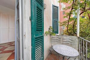 a table on a balcony with a green door at Monolocale Isotta in Finale Ligure