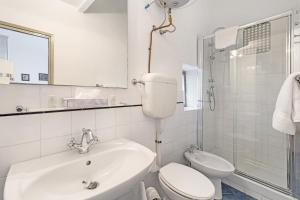 a white bathroom with a toilet and a sink at Monolocale Isotta in Finale Ligure +5 photos