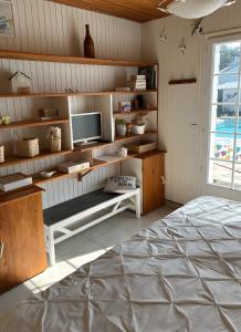 a room with a bed and a tv and shelves at Maison d'Hôtes - La Marée Hôtes in Piriac-sur-Mer