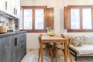 a kitchen and living room with a table and a couch at Camarón Suite in Granada +10 photos