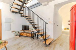 a spiral staircase in a living room with a tv at Camarón Suite in Granada