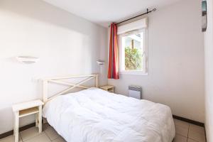 a bedroom with a white bed and a window at Appartement - Terrasses De L'Océan in Moliets-et-Maa +17 photos